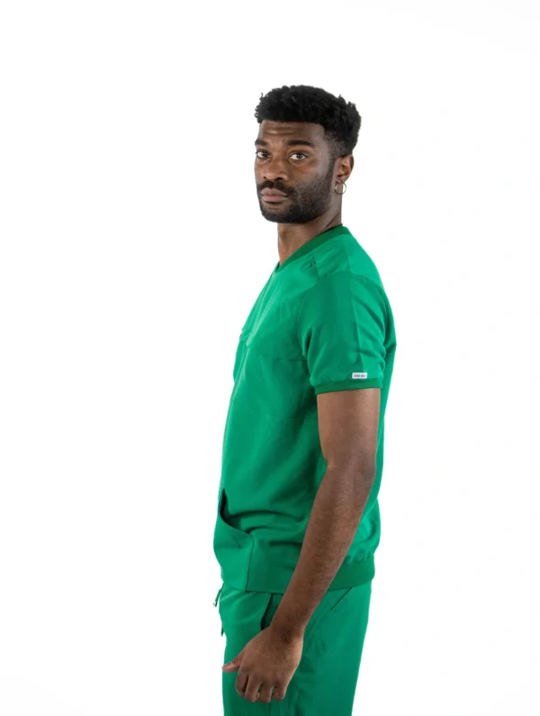 A man in green scrubs is standing up.