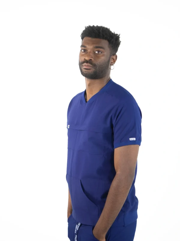 A man in blue scrubs is standing up.