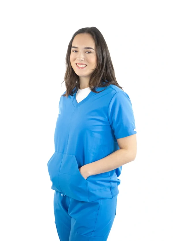 A woman in blue scrubs is smiling for the camera.