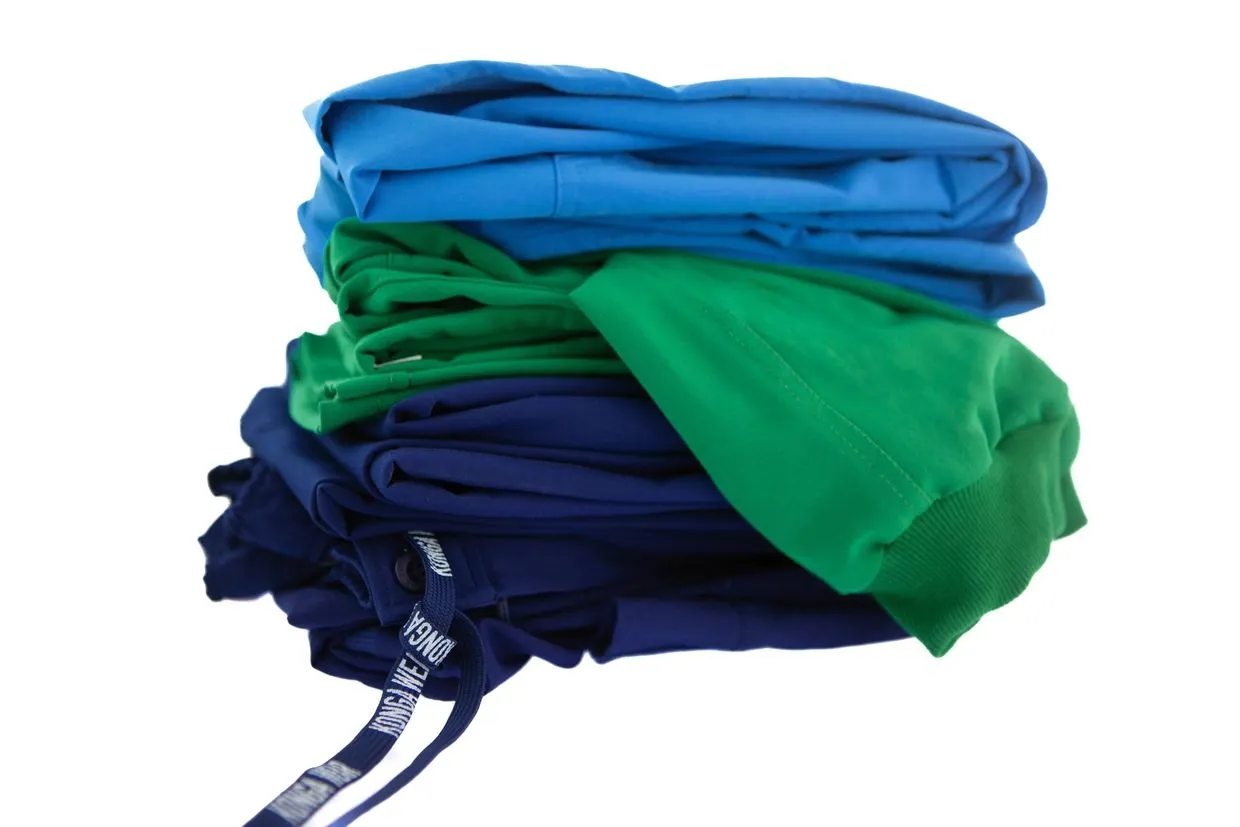 A pile of blue and green shirts on top of each other.